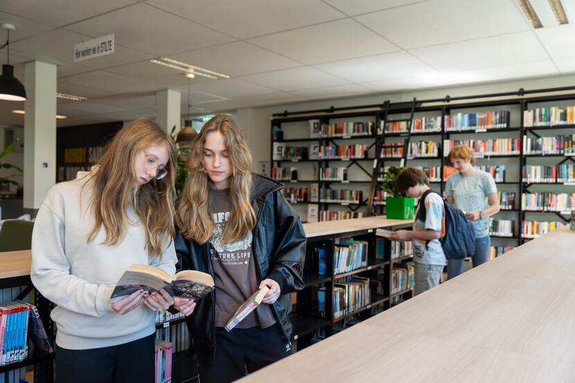 Leerlingen kiezen een boek uit in de schoolmediatheek