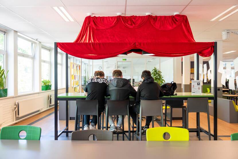 Drie leerlingen zitten in de schoolmediatheek