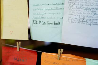 Door leerlingen geschreven boekrecensies hangen aan een lijn met knijpers